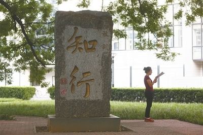 8月25日，北京交通大学，一名学生在校训石碑旁读书。摄影/新京报记者浦峰