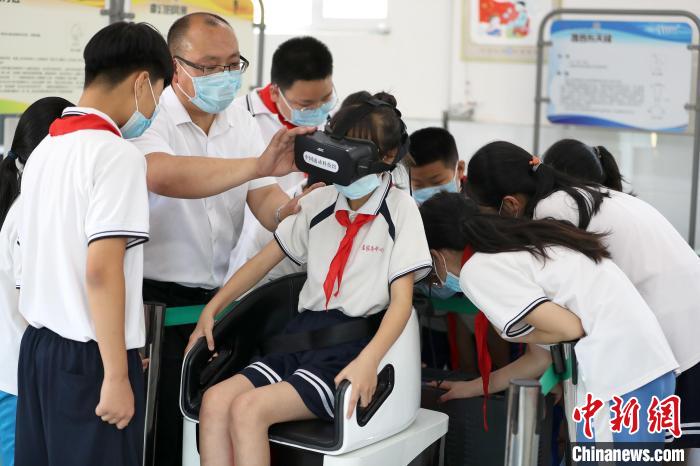 在文安县孟家务中心小学的流动科技馆，学生在体验VR眼镜。　高丹钰 摄