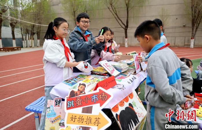 世界读书日 青海西宁小学生校园“跳蚤市场”淘书