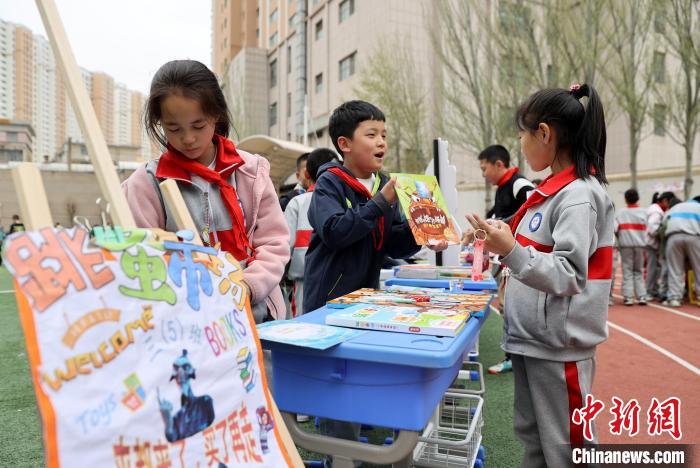 世界读书日 青海西宁小学生校园“跳蚤市场”淘书