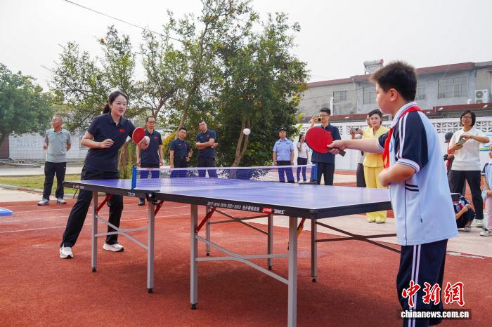 河南新乡：乒羽冠军进校园与学生互动打球
